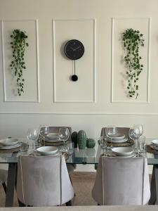 a dining table with chairs and a clock on the wall at 'Il Duomo' nel centro di Frascati in Frascati