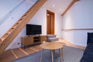 a living room with a tv and a table at Domaine du Rondia - Chambres d'hôtes et Wellness in Wanze