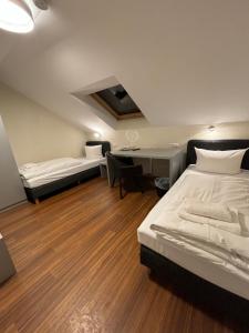 a hotel room with two beds and a desk at Pension Gergert am Neckar in Neckarsulm