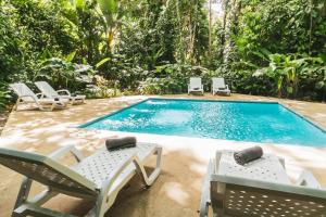 a pool with chaise lounge chairs and a swimming pool at Peaceful Jungle Villa Kona - Pool & Parking for 2 persons in Puerto Viejo