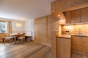 una cucina con pareti in legno e un tavolo con lavandino di La Gemma a Celerina