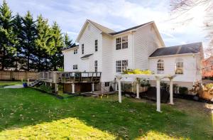 a white house with a porch and a deck at Z Presidential Suite in Upper Marlboro