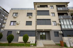 an apartment building with black shuttered windows at Apartament Azer Eforie Nord in Eforie