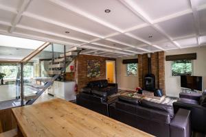 een woonkamer met een bank en een tafel bij Wootton, woodland lodge with hot tub for 8 in Oakamoor