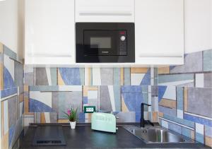 a kitchen with a microwave above a sink at Athena Rooms - Parcheggio privato in Bologna