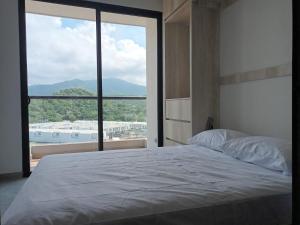 a bedroom with a large bed and a large window at La posada de Mayté in Santa Marta