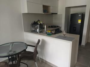 a small kitchen with a table and a black refrigerator at La posada de Mayté in Santa Marta +5 photos