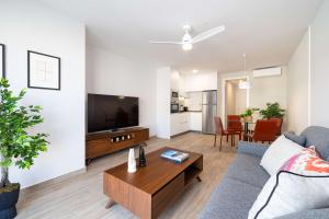 a living room with a couch and a tv at Beach and golf at modern apartment in Caleta De Velez