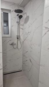a bathroom with a shower with white marble walls at Bella Vacanza Apartment in Banja Luka +48 photos