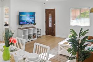 Una sala de estar con una mesa de comedor y un televisor. en Modern 2B1B Near SAP, SJSU, Convention Center, en San José