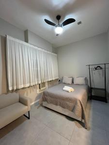 ein Schlafzimmer mit einem Bett und einem Deckenventilator in der Unterkunft Loft Icaraí in Niterói