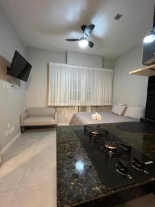 ein Schlafzimmer mit einem Bett und eine Küche mit einem Herd in der Unterkunft Loft Icaraí in Niterói