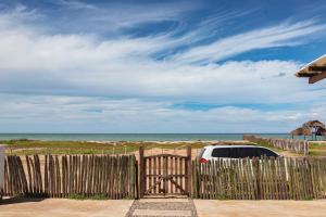 a car parked behind a wooden fence near the beach at Refugio, Casa de la Playa in Manaure