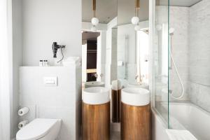 a bathroom with two sinks and a toilet and a tub at Senato Hotel Milano in Milan