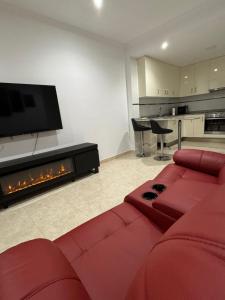 a living room with a red couch and a fireplace at El refugio del amor in Fuentealbilla