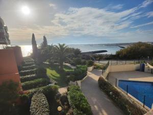 a view of a house with a swimming pool and the ocean at Appartement vue mer in Sète