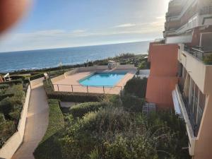 an aerial view of a building with a swimming pool and the ocean at Appartement vue mer in Sète