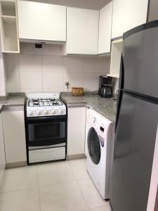 a kitchen with a stove and a washing machine at SkyHome Córdoba, Terraza y Piscina Panorámica in Córdoba