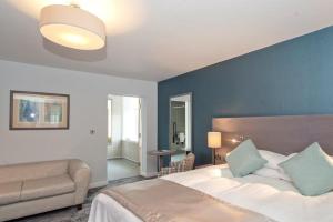 1 dormitorio con 1 cama grande y 1 sofá en The Portland Hotel Wetherspoon en Chesterfield