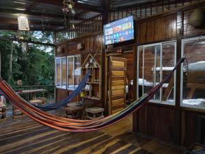 a hammock in a room with a tv at Cabaña Estuario Capurganá in Capurganá