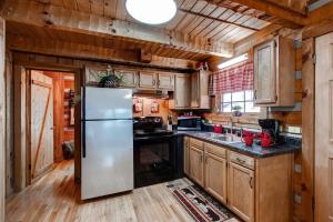 a kitchen with wooden cabinets and a refrigerator at Mountain Hideaway in Pigeon Forge