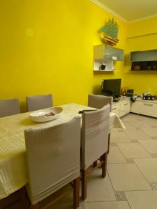 a yellow dining room with a table and chairs at Tirana Center Apartaments in Tirana