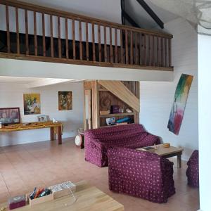 a living room with a couch and a staircase at villa timokei piscine et jacuzzi in Fond Saint-Jacques