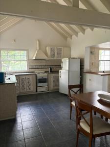 eine Küche mit weißen Geräten und einem Tisch mit Stühlen in der Unterkunft casa quincho Puerta de la Quebrada in La Rioja