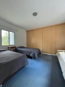 1 Schlafzimmer mit 2 Betten und blauem Boden in der Unterkunft casa quincho Puerta de la Quebrada in La Rioja