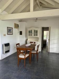 ein Esszimmer mit einem Tisch, Stühlen und einer Mikrowelle in der Unterkunft casa quincho Puerta de la Quebrada in La Rioja