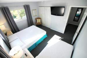 フォート・ローダーデールにあるTarpon Harbor 2 - Waterfront townhouse near pool, beach, downtown Las Olasのベッド2台とテレビがあるホテルの部屋