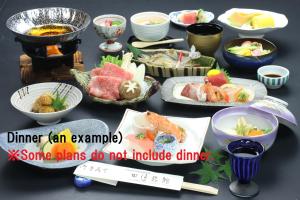 a table topped with plates of food and chopsticks at Ryokan Tanabe 旅館田邊 in Takayama
