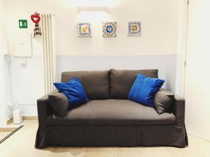 un divano marrone con cuscini blu in soggiorno di Scala Santa Home a Roma
