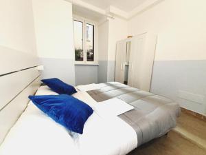 una camera bianca con 2 letti con cuscini blu di Scala Santa Home a Roma