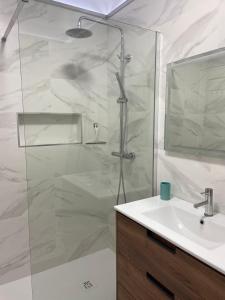 a bathroom with a shower with a sink and a mirror at Apartamento Vista Mar in Praia da Vieira