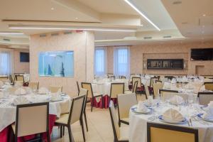 ein Festsaal mit weißen Tischen und Stühlen in der Unterkunft Hotel Milazzo in Milazzo