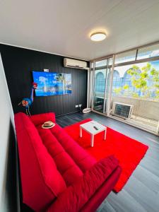 a living room with a red couch and a red rug at Tahiti Sunshine in Papeete