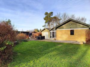 a yellow brick house with a large yard at 4 star holiday home in Hals in Hals