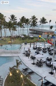 un complexe avec un billard, des tables et des palmiers dans l'établissement Porto Alto Resort, à Porto de Galinhas
