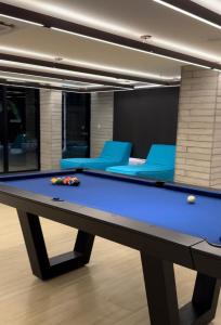 - un billard dans une pièce avec des chaises bleues dans l'établissement Porto Alto Resort, à Porto de Galinhas
