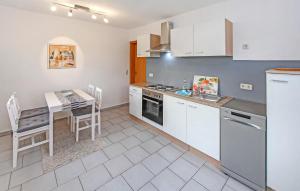 a kitchen with white cabinets and a table with a tableablish at Ferienhaus Saal Bartelshagen in Bartelshagen