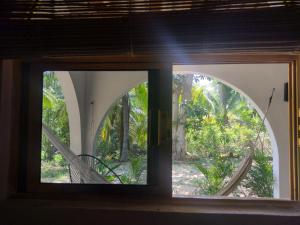 an open window with a view of a garden at Casa pájaros- Habitación Colibri in Troncones