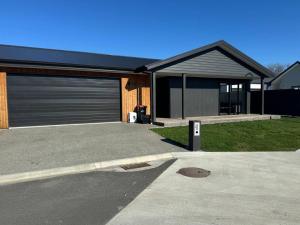 a house with a parking lot with a garage at Modern & Homely - Double Garage in Napier