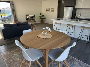 a living room with a wooden table and chairs at Modern & Homely - Double Garage in Napier