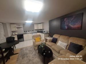 a living room with a couch and a table and a kitchen at Login house A in Derry Londonderry +28 photos