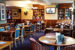 a dining room filled with tables and chairs at The Catherine Wheel Wetherspoon Hotel in Henley on Thames