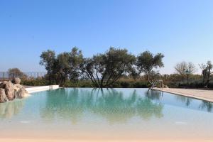 una piscina di acqua con alberi sullo sfondo di Badiula a Carlentini