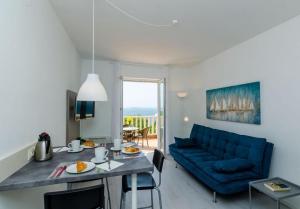 a living room with a blue couch and a table at Apartments and rooms with parking space Plat, Dubrovnik - 23567 in Mlini