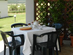 a table with a white table cloth on it with chairs at Agriturismo Severini in Fonteblanda