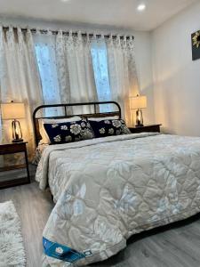ein Schlafzimmer mit einem Bett mit zwei Lampen und zwei Fenstern in der Unterkunft K1 Private Bathroom Queen Bed Room in Mississauga